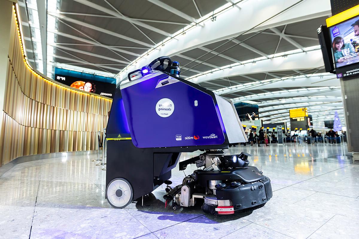 A purple cleaning robot in a terminal at Heathrow Airport